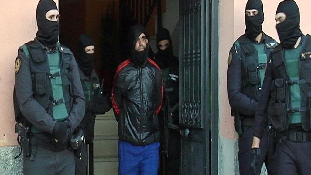 Poliisi saattoi Isis-värväriksi epäillyn miehen ulos kodistaan Ceutassa 12. joulukuuta 2015.