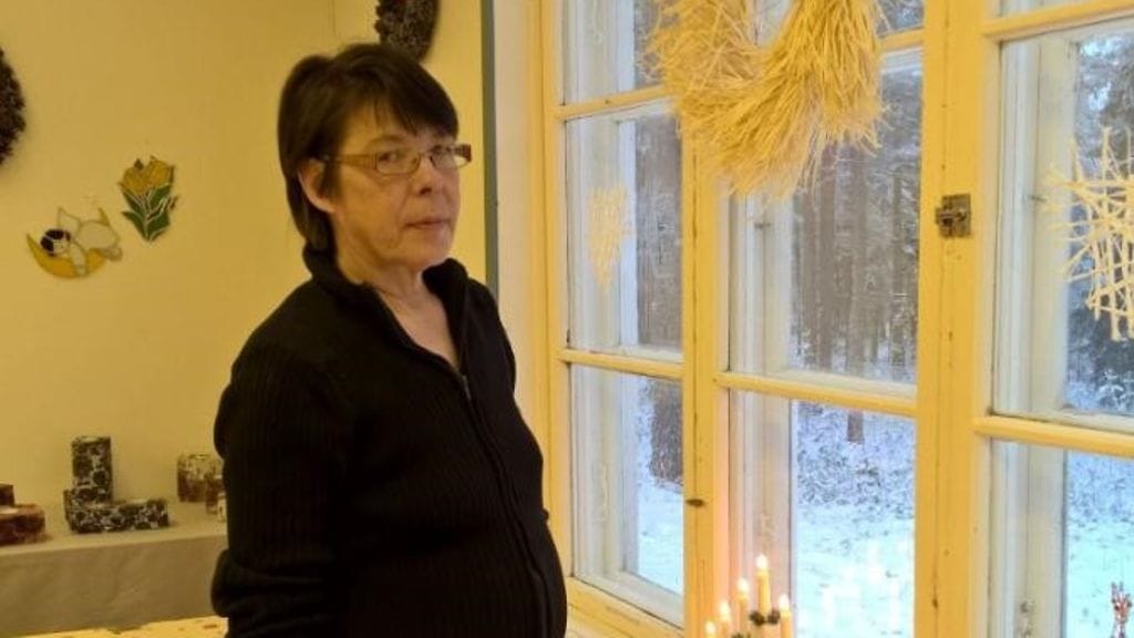 Pirjo on kuvassa työpaikallaan, jossa – toisin kuin kotona – on myös joulukoristeita näkyvillä.