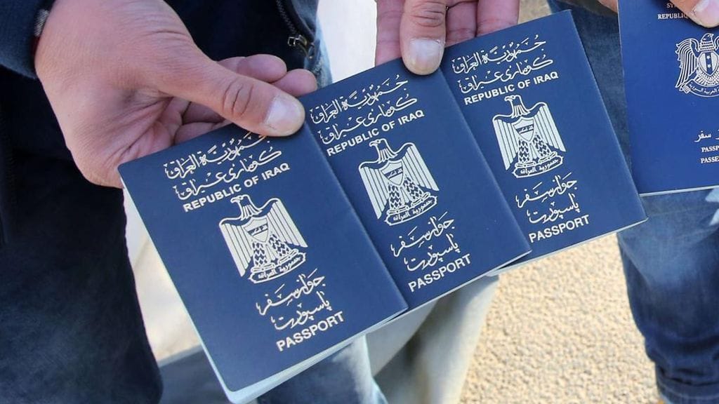Kuvituskuva. Pakolaiset näyttävät Irakin ja Syyrian passejaan.