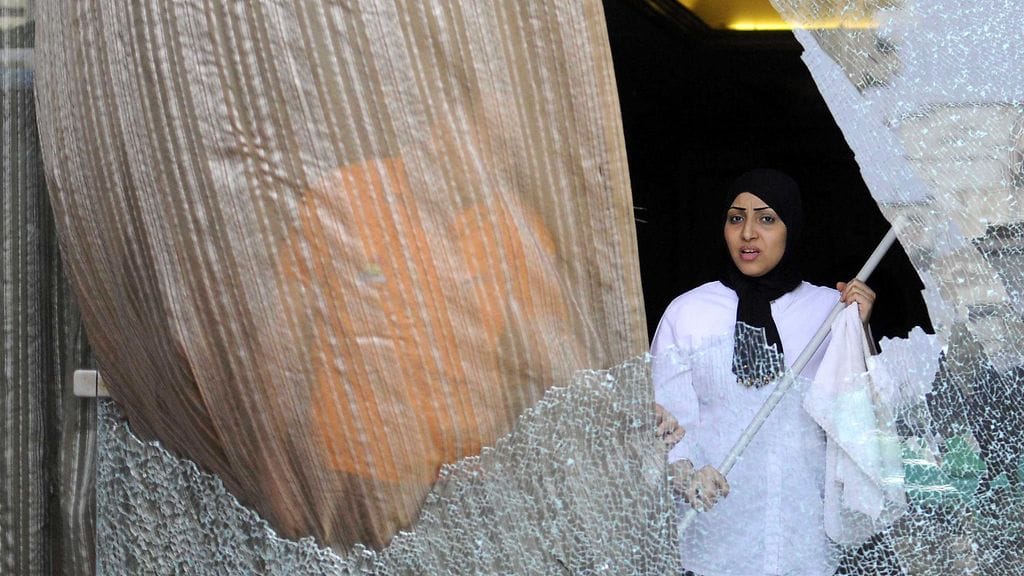 Hotellin työntekijä siivosi ampumisessa rikkoutunutta ikkunalasia Gizassa 7. tammikuuta 2016.