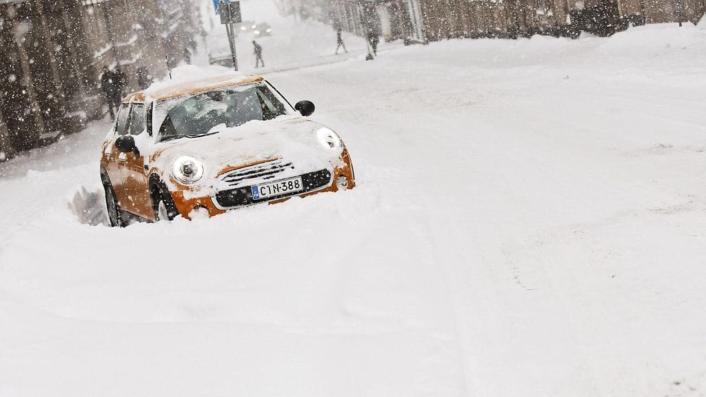 Auto jumissa lumikinoksissa Fabianinkadulla Helsingissä tiistaina 12. tammikuuta 2016.