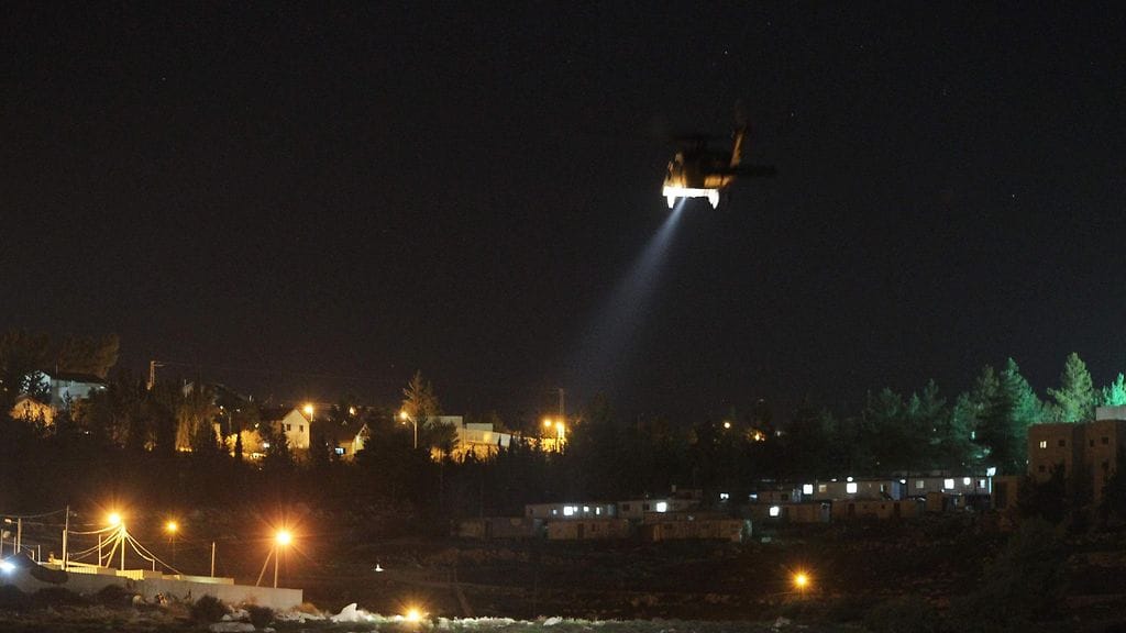Israelin armeijan helikopteri lentää siirtokunnan yläpuolella Länsirannalla etsien juutalaisnaisen murhasta epäiltyä.