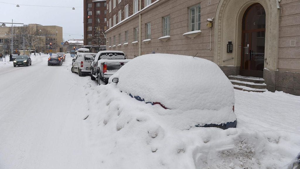 Pysäköityjä autoja lumessa Helsingin Runeberginkadulla 18. tammikuuta 2016.