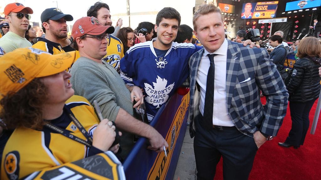 Leo Komarov poseerasi Toronto Maple Leafsin fanin kanssa punaisella matolla ennen lauantain taitokisoja.