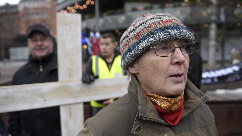 Rajat kiinni -ryhmä kantoi puista ristiä lauantaina mielenosoituksessa.