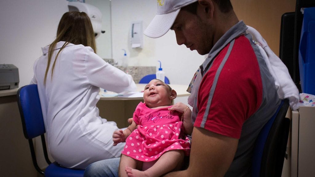 Mikrokefaliaan sairastunut pikkuinen Ana Beatriz isänsä sylissä Recifessä Brasiliassa tammikuun lopussa. Ana Beatriz on yksi yhteensä 4000 mikrokefalian saaneesta vauvasta maassa.