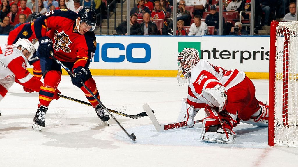 Aleksander Barkov nosti kiekon Jimmy Howardin ohi.