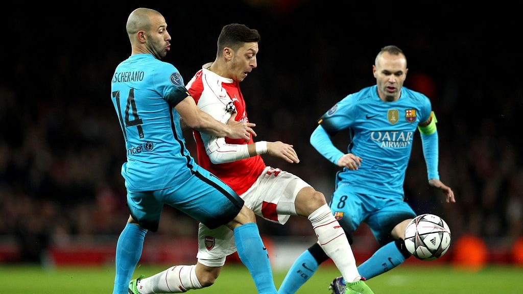 Barcelonan Javier Mascherano ja Andres Iniesta paimentavat Mesut Öziliä (kesk.).