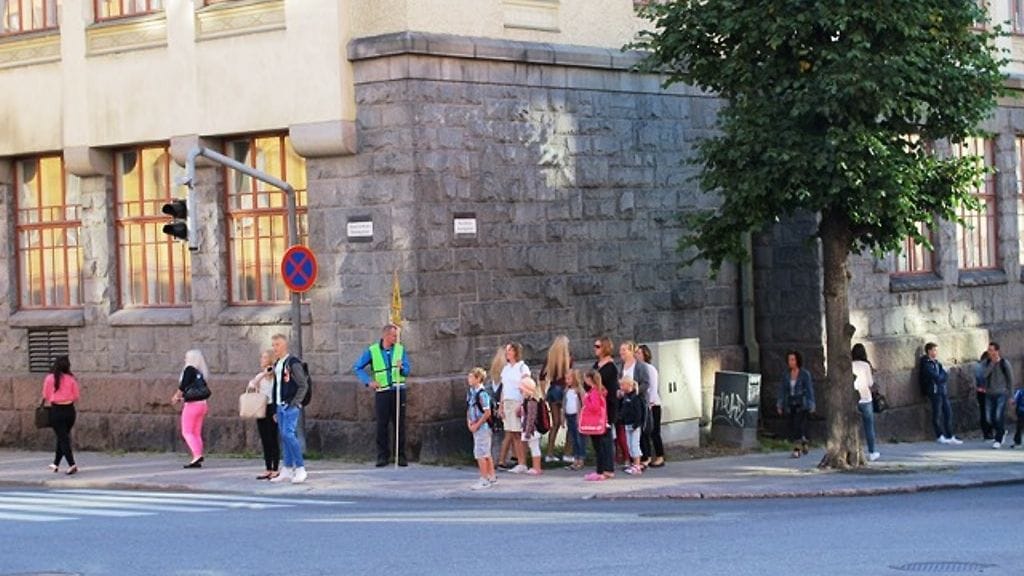 Kouluvaari Juhani Löflund seuraa turvallista suojatien ylitystä. Kuva: Roger Nylund.