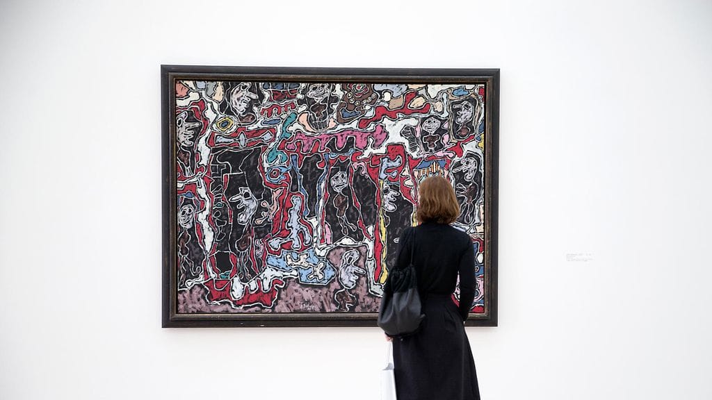 Nainen katsoo Jean Dubuffetin maalausta sveitsiläisessä museossa