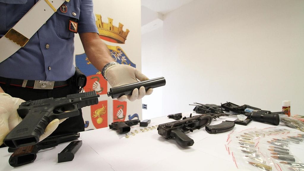 Italian poliisin takavarikoimia aseita ja huumeita.