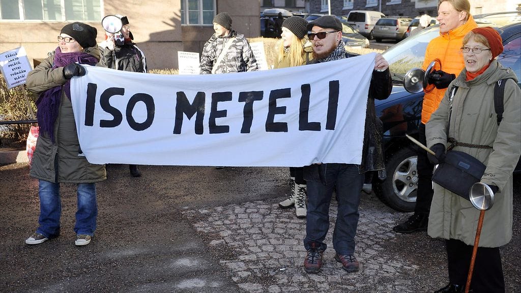 Parikymmentä Joukkovoima-kansanliikkeen mielenosoittajaa osoitti mieltä hallituksen leikkauksia vastaan Helsingissä lauantaina 13. helmikuuta 2016.