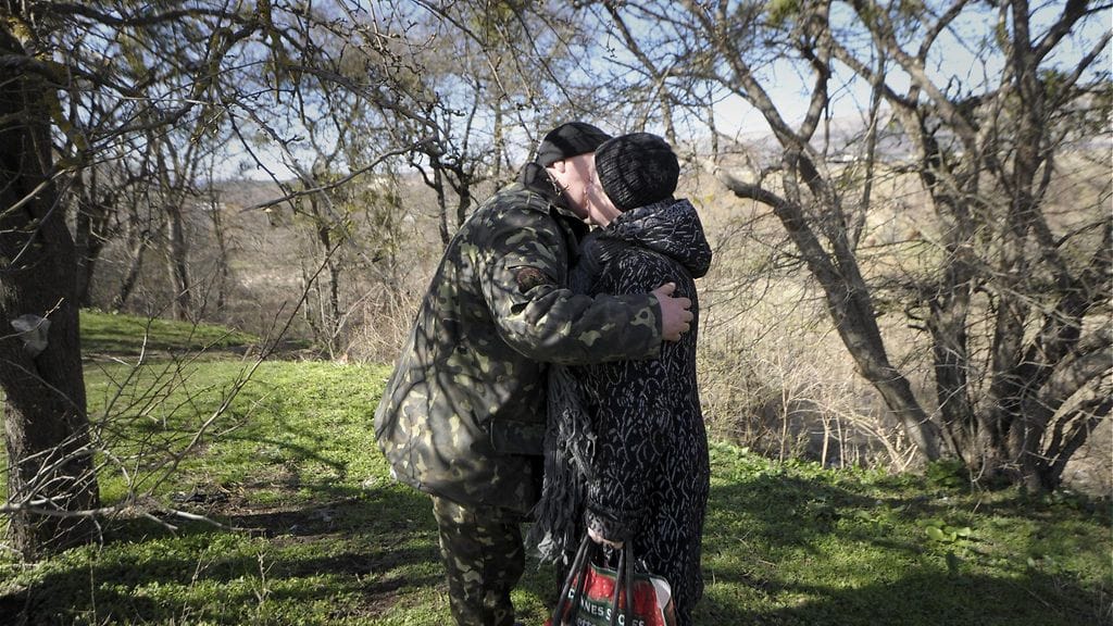 Ukrainalaissotilas tervehti ruokaa tuovaa äitiään venäläisten piirittämässä varuskunnassa Perevalnojen kylässä Krimin niemimaalla Ukrainassa maanantaina 17. maaliskuuta 2014.