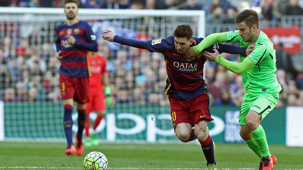 Getafen Alvaro Medran yrittää pysäyttää Lionel Messin.