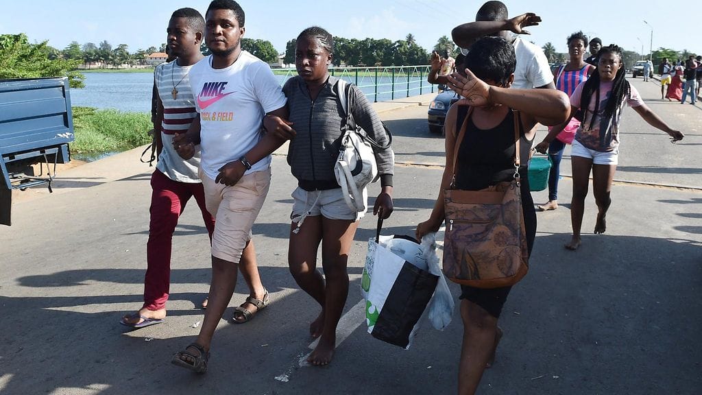 Ihmiset poistuivat Grand-Bassamin rantakohteesta ampumisen jälkeen 13. maaliskuuta 2016.