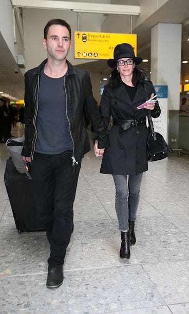 John McDaid ja Courteney Cox ja matkalaukku