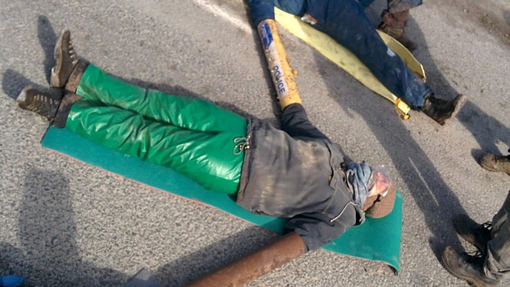 Stop Fennovoima -verkoston aktivistien handout-kuvassa näkyy, kuinka aktivistit sulkivat tien lähellä Pyhäjoen ydinvoimalatyömaata 28. huhtikuuta 2016. Aktivistit kertoivat muodostaneensa ihmisketjun lukittautumalla toisiinsa ja betonitynnyreihin.