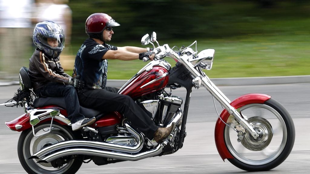 Lapsi moottoripyörän kyydissä.