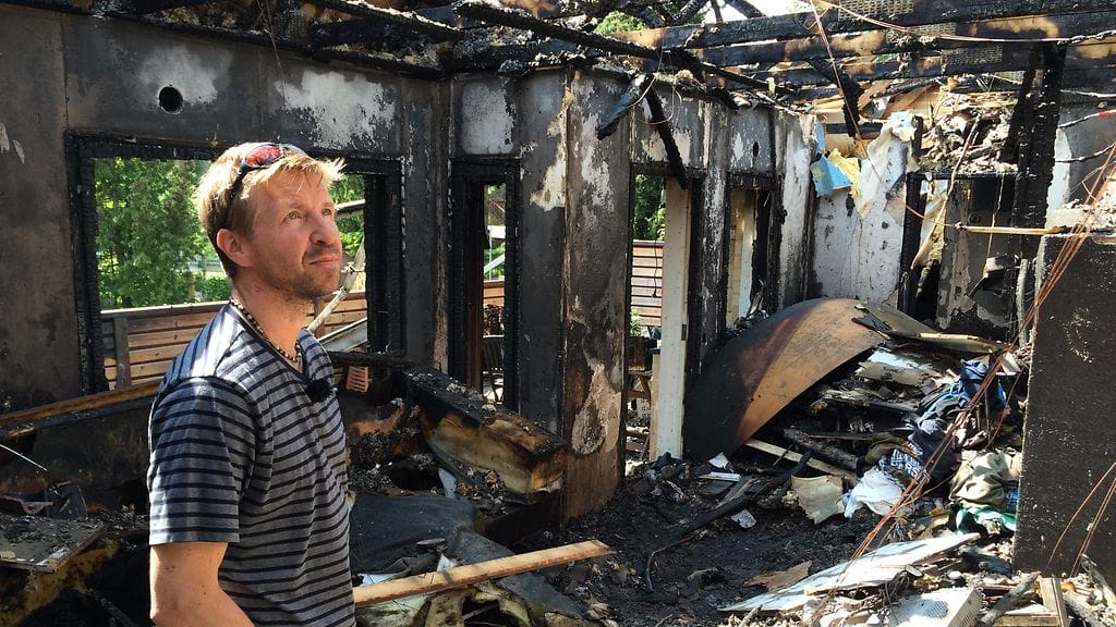 Markku Finne tutkii täysin palaneen talonsa raunioita. Tulipalo syttyi latauksessa olleesta tasapainoskootterista.