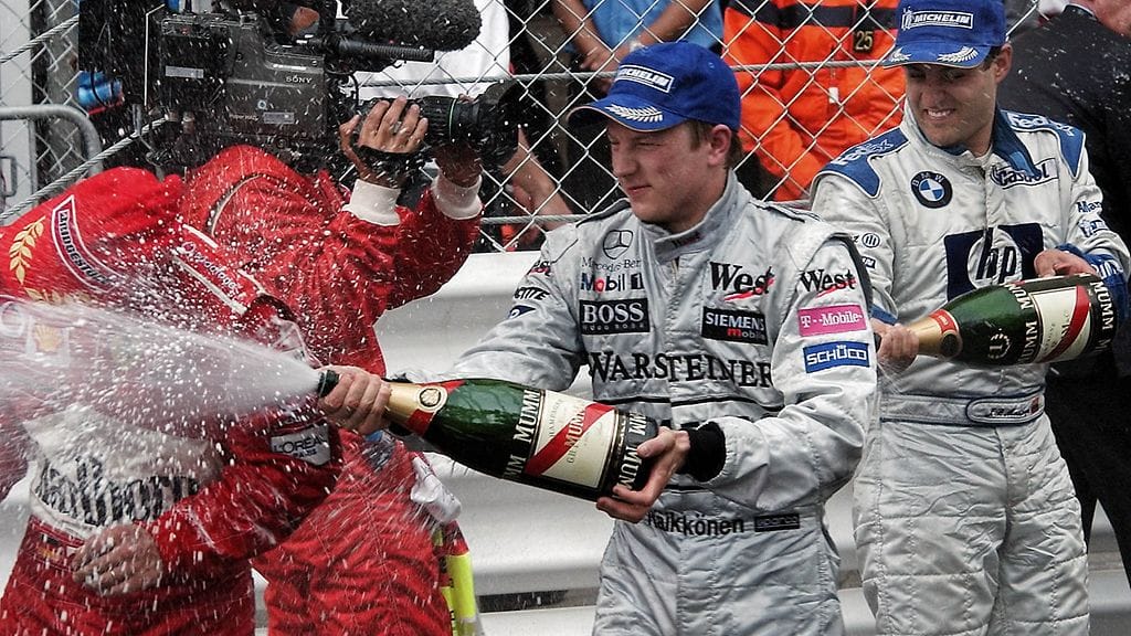 Kimi Räikkönen kastelee Michael Schumacherin samppanjalla Monacon GP:ssä 2003.