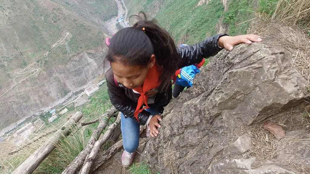 Kiinalaislapset joutuvat kiipeämään kallionrinnettä päästäkseen koulusta kotiin.