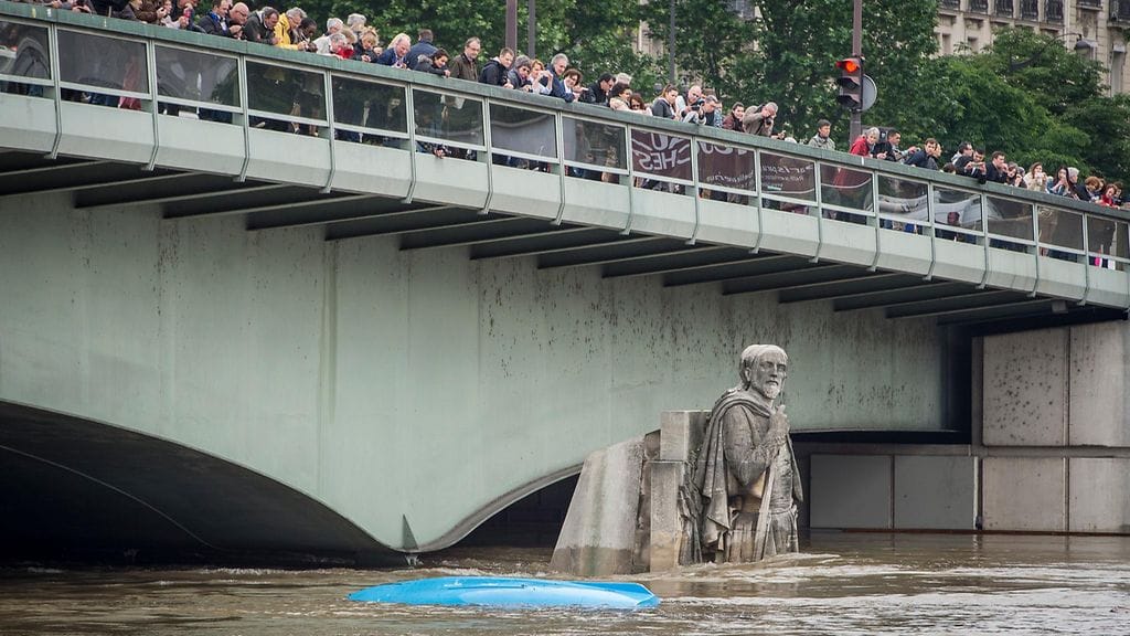Ihmiset katselivat kohonnutta joenpintaa Pont de l’Almalla. Le Zouave –patsas oli osittain veden alla 3. heinäkuuta Pariisissa.
