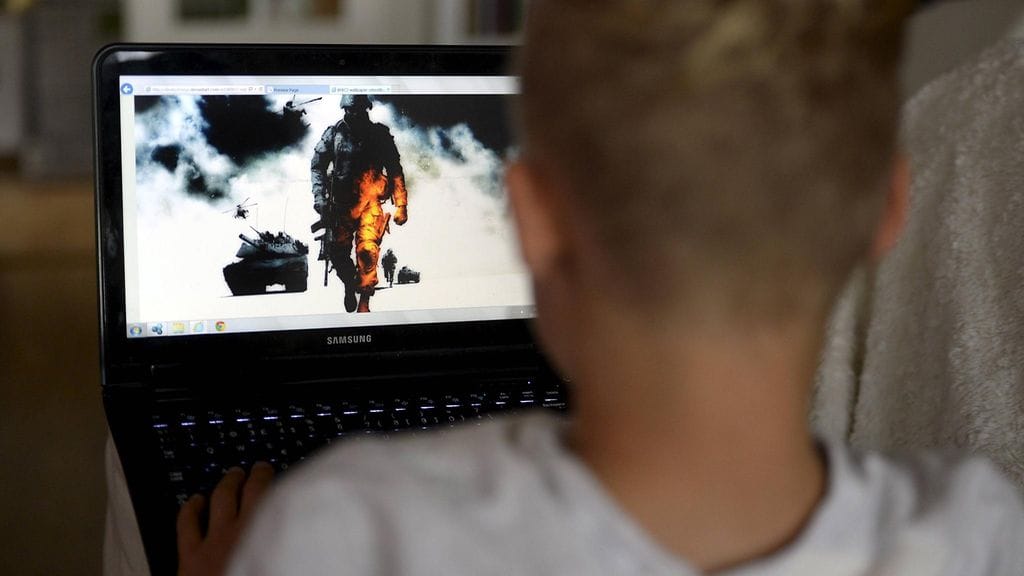 Kuvituskuva. Teinipoika pelaa tietokoneella.