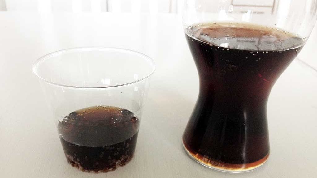 Vasemmalla näkyy, miten hiilihapot tarrautuvat muovimukin reunoihin. Oikeanpuoleisessa, Riedelin erityisesti Coca-Colalle suunnitellussa lasissa hiilihappoja ei näy.