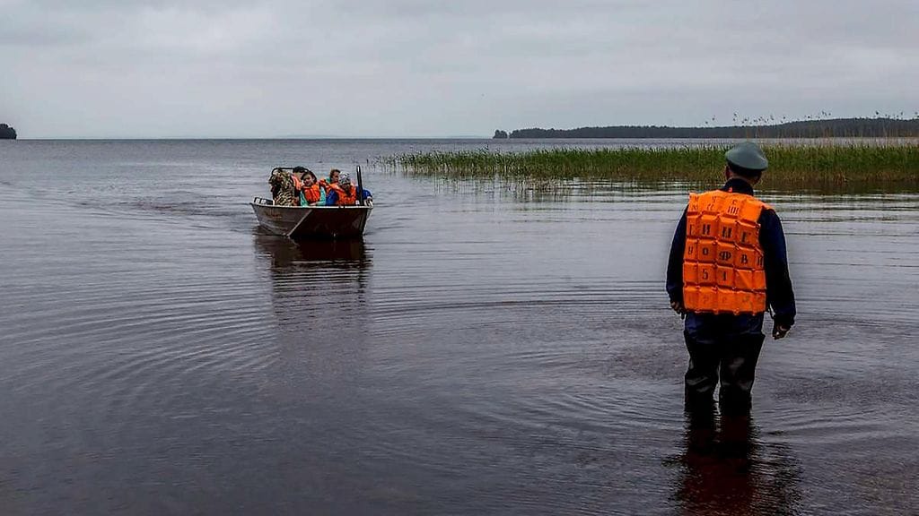 Kuva pelastustöistä, kun turmasta pelastuneita lapsia tuotiin rantaan.
