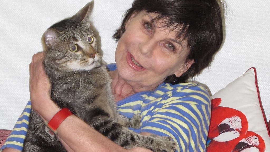 Toimittaja Pirkko Arstila ja Eetu-kissa tulipalon jälkeen evakkoasunnossa. Kuva: Merja Halinen.