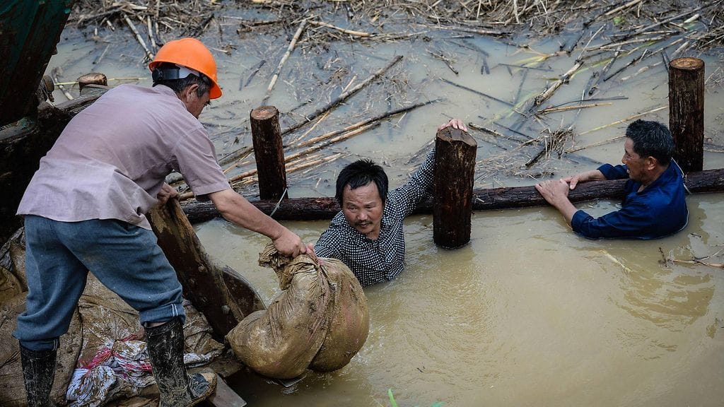 Miehet vahvistivat patoa Nanjingissa Kiinassa 7. heinäkuuta 2016. Jangtse-joen tulviminen aiheutuu poikkeuksellisen rankoista monsuunisateista.