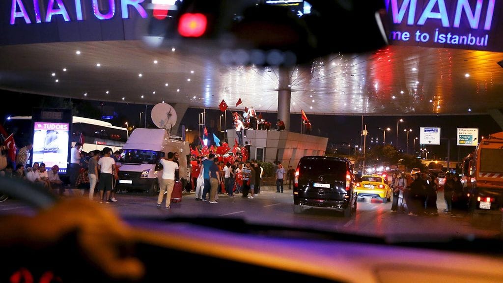 AKP-puolueen kannattajia osoittamassa mieltä hallituksen puolesta Ataturkin lentokentän edustalla Istanbulissa.