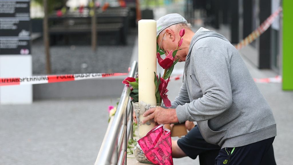Mies muistaa eilisillan ammuskelun uhreja Saksassa.
