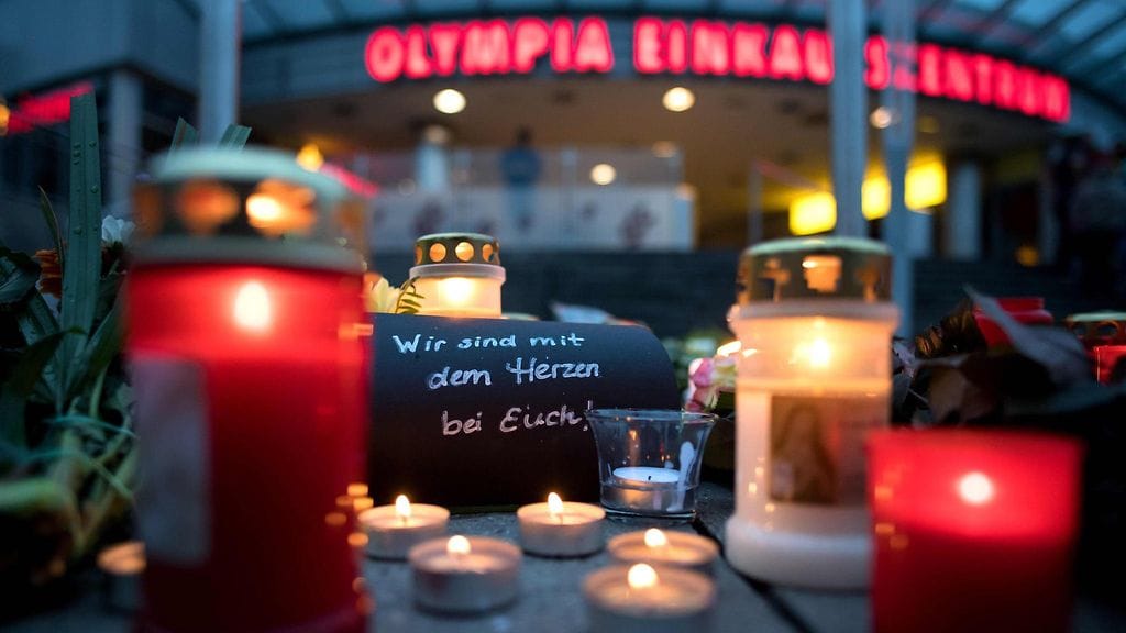 Kynttilöitä ja muistolause Olympia-kauppakeskuksen edessä Münchenissä. "Olemme sydämissämme luonanne".