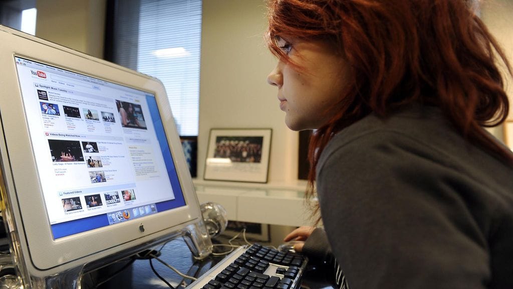 Tyttö selaa Youtube tietokoneella.