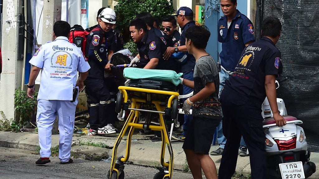 Pelastustyöntekijät vievät uhria hoitoon Hua Hinissa, jossa räjähti pommi perjantaina 12.8. Neljä ihmistä kuoli ja 35 haavoittui iskuissa, joita tehtiin eri puolilla maata turistikohteissa.