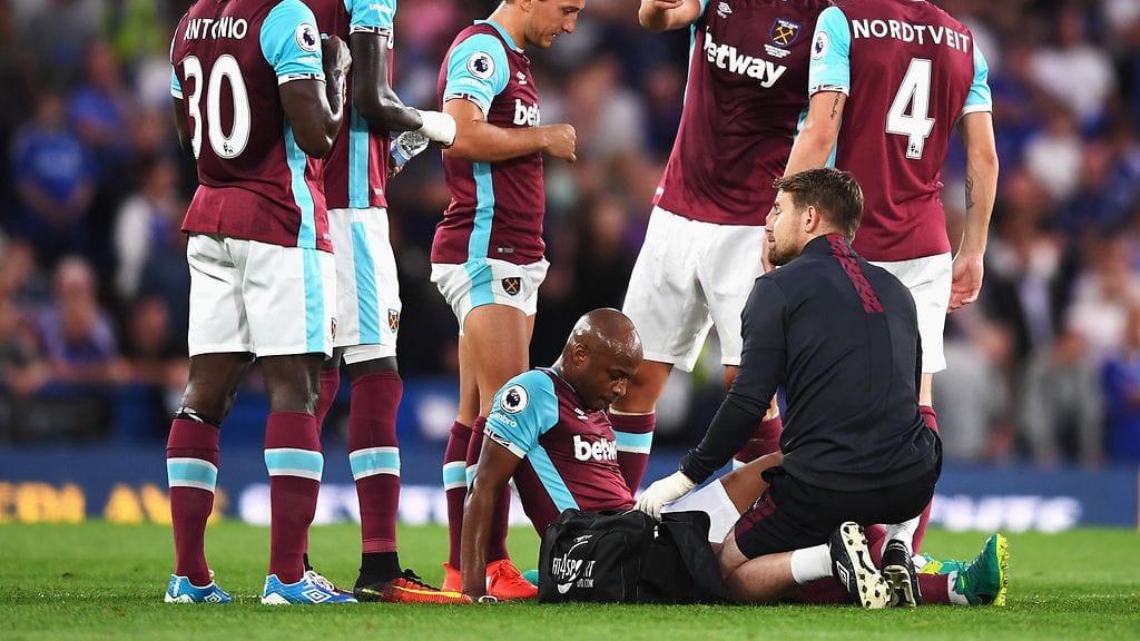Andre Ayew (kesk.) vastaanottaa hoitoa pelissä Chelseaa vastaan.