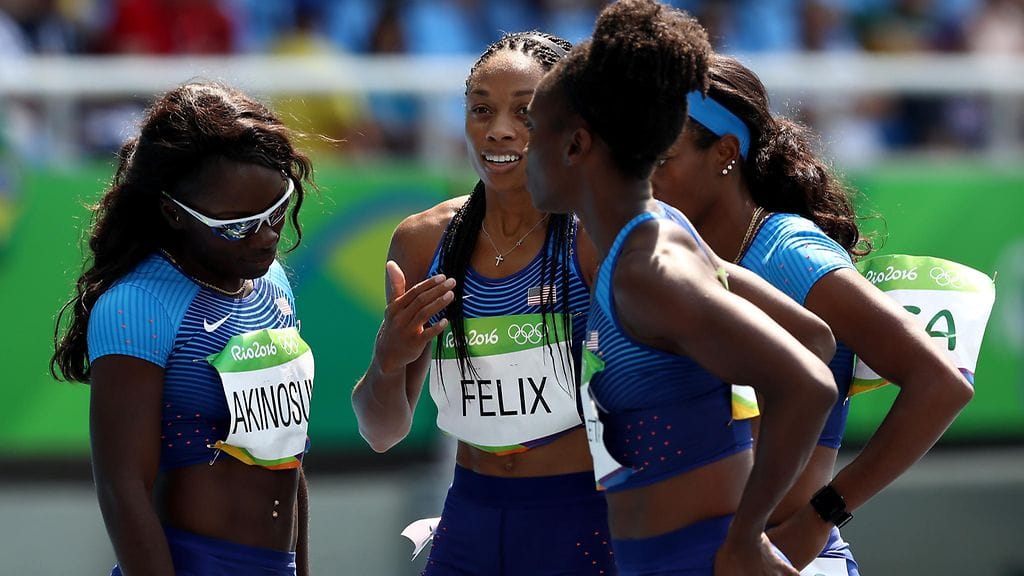 Allyson Felix selittää kömmähdystä joukkuekavereilleen.