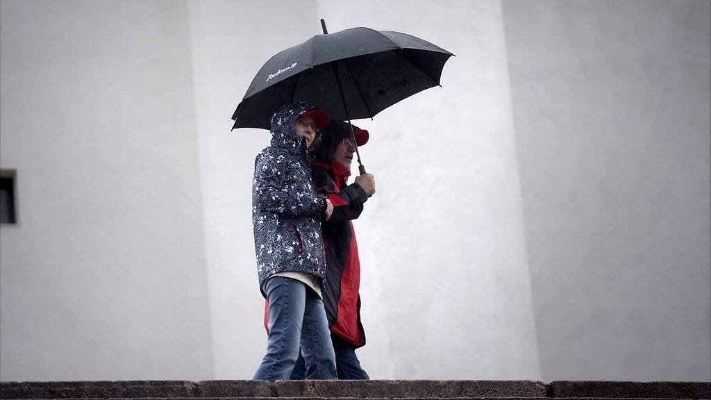 Ihmisiä sateenvarjon alla Helsingissä 27. kesäkuuta 2016. Taiteiden yöhön kannattaa tänään ottaa sateenvarjo mukaan.