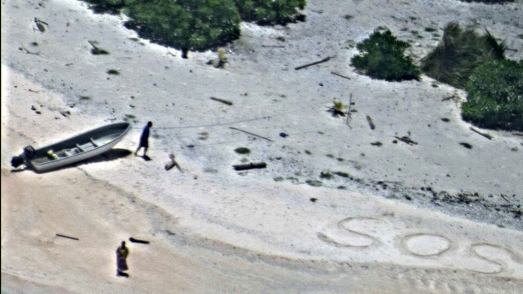 Yhdysvaltain laivaston lentokoneesta ottama kuva pariskunnasta ja SOS-merkistä Mikronesian saarella.