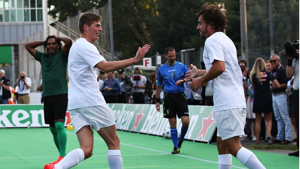 Max Verstappen (vas.) ja Fernando Alonso paiskasivat kättä jalkapallon näytösottelussa, jossa F1-kuskien joukkue kohtasi entiset UEFA Champions Leaguen tähdet.