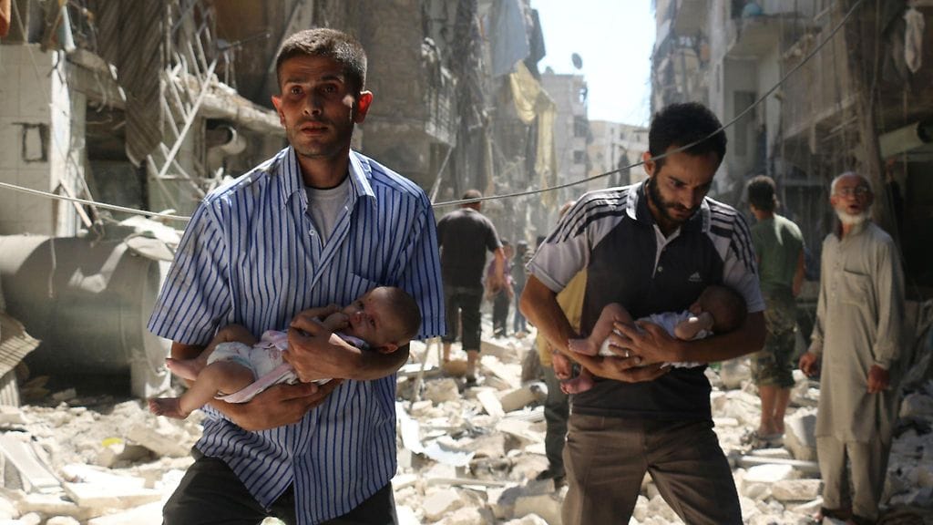 Miehet kantavat vauvoja ulos raunioista Aleppossa 11. syyskuuta 2016.