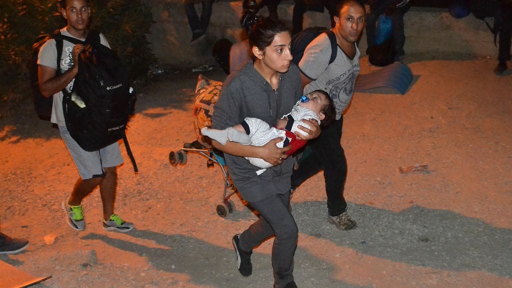 Nainen pakeni lapsensa kanssa laajalle levinnyttä tulipaloa Morian leirillä Lesboksen saarella Kreikassa.