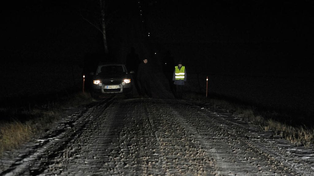 Pimeällä tiellä jalankulkija erottuu selvästi heijastimen kanssa. Autoilija ilman heijastinta taas ei.