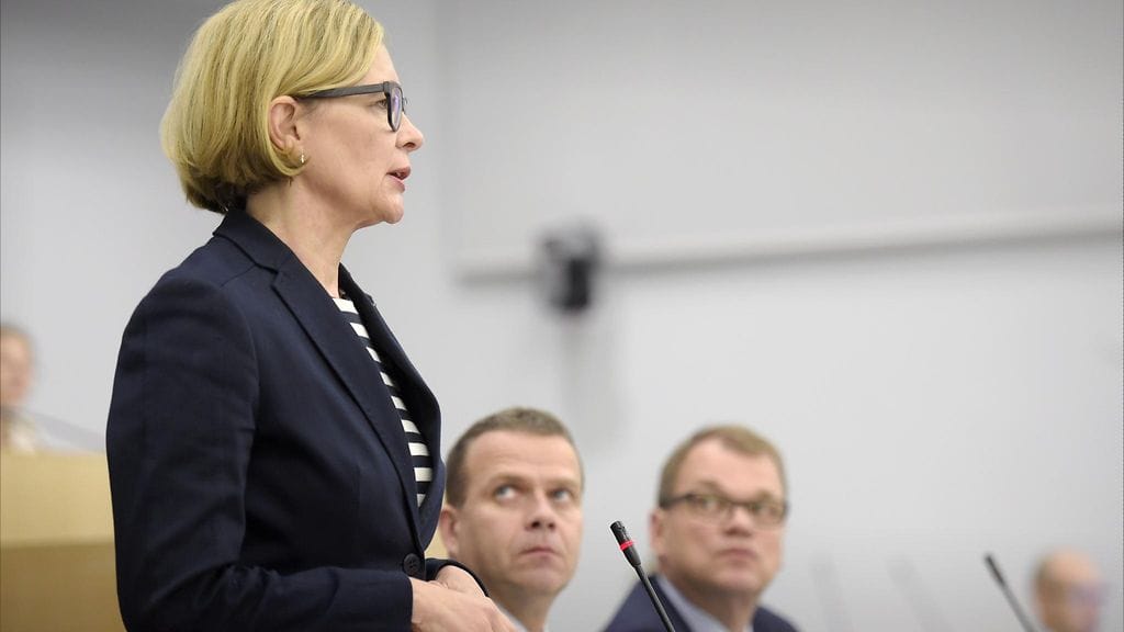 Sisäministeri Paula Risikko (kok.) puhuu suullisella kyselytunnilla eduskunnassa Helsingissä 22. syyskuuta 2016. Vieressä valtiovarainministeri Petteri Orpo (kok.) ja pääministeri Juha Sipilä (kesk.).