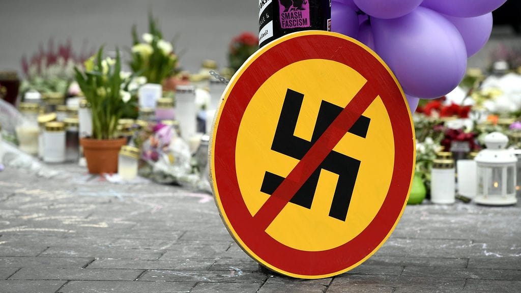 Hakaristin kieltävä omatekoinen liikennemerkki sekä muistokynttilöitä Suomen vastarintaliikkeen mielenosoituksessä pahoinpidellyn uhrin muistoksi Asema-aukiolla Helsingissä perjantaina 23. syyskuuta 2016.