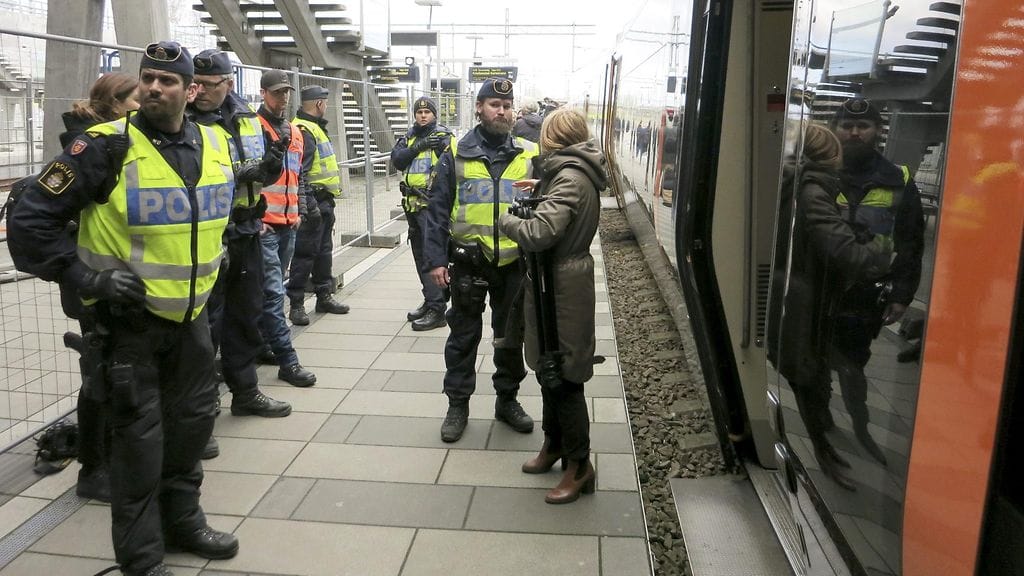 Ruotsin poliisi tarkasti matkustajien henkilöpapereita Etelä-Ruotsin Malmössä Hyllien juna-asemalla, Tanskan rajan tuntumassa torstaina 12. marraskuuta 2015.
