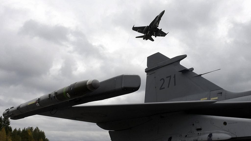 Kuvassa Hornet-torjuntahävittäjä lentää yli ruotsalaisen Gripenin Karjalan lennoston järjestämässä Baana 2016 -lentotoimintaharjoituksessa Heinolan Lusin varalaskupaikalla 28. syyskuuta 2016.