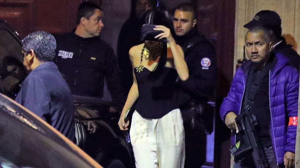 Kim Kardashian poistuu hotellista jouduttuaan naamioituneiden miesten ryöstämäksi.