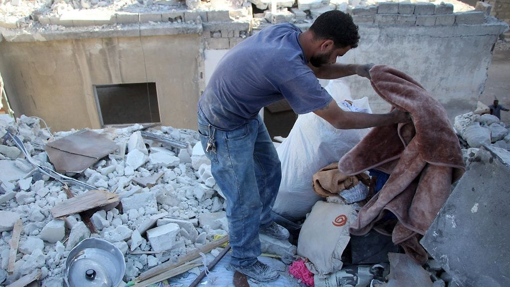 Yehya Maatouq kaivaa talonsa raunioita.